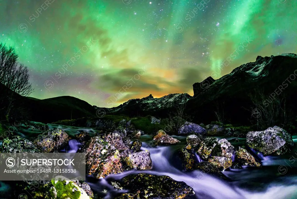 Aurora borealis over landscape with small river near the Sethaugelva lake in Tromvik, Norway