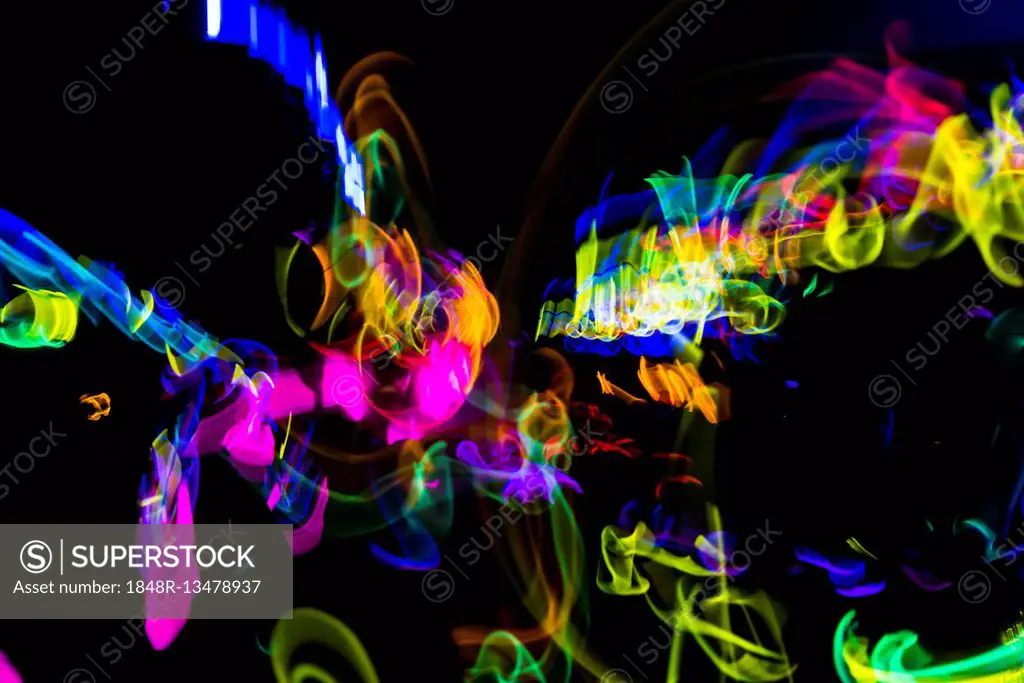 Colorful lights from glow sticks at a dark party using long exposure light effect