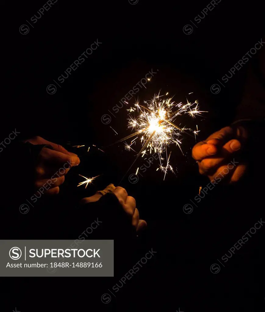 Burning sparklers in hands, symbil image party, fireworks, New Year's Eve