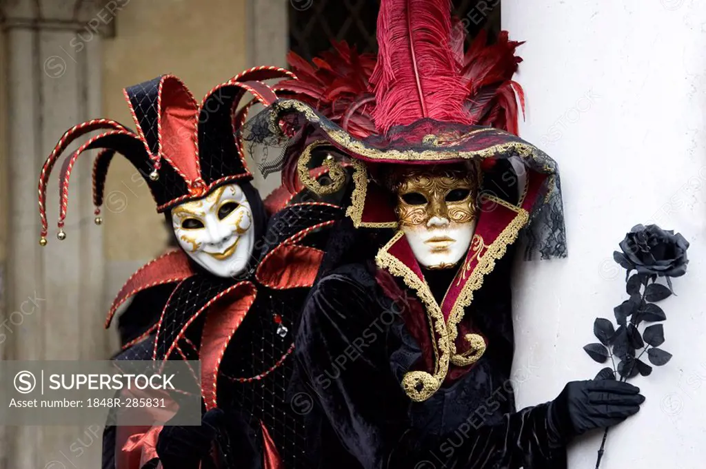 Harlequin (court jester) costume and elegant lady with black rose in hand, Carnevale di Venezia, Carneval in Venice, Italy