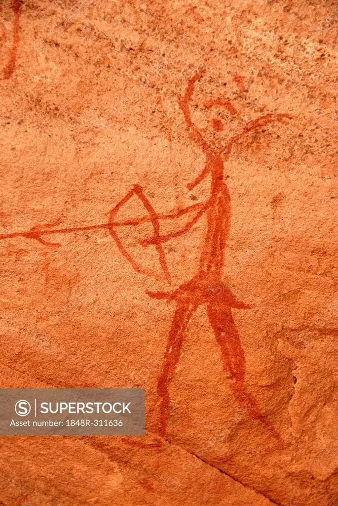 Neolithic rock drawing of a human with bow and arrow and an animals head Acacus Libya