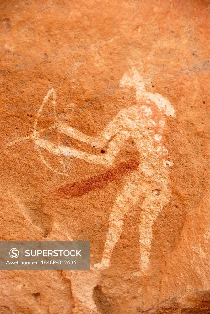 Neolithic rock drawing of a hunting man with weapons bow and arrow Acacus Libya