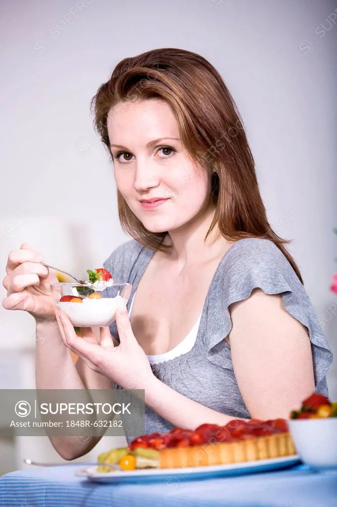 A young woman eating yogurt