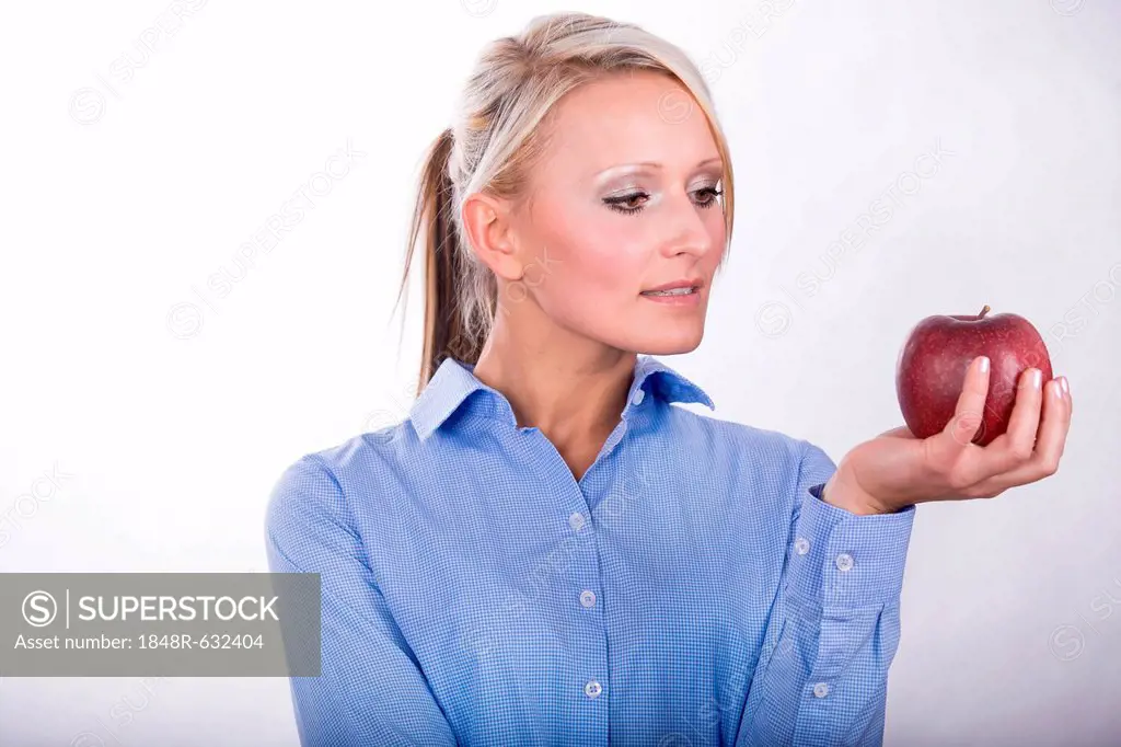 A young woman holding an apple