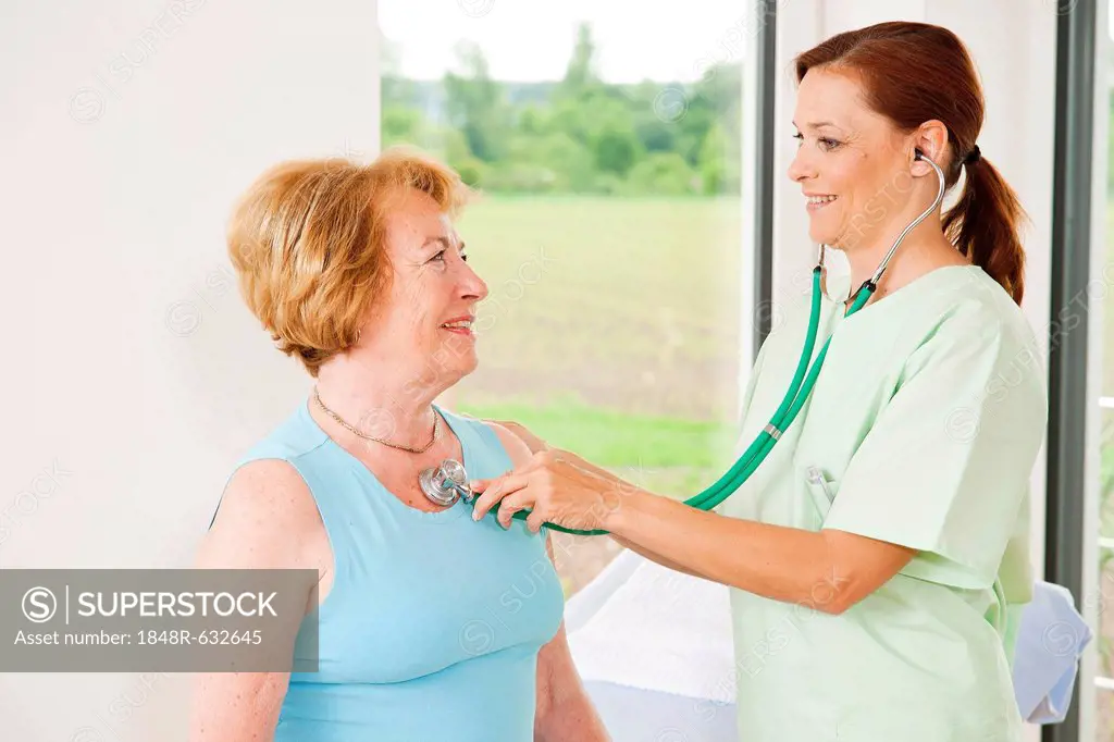 Patient being monitored by her family doctor with a stethoscope