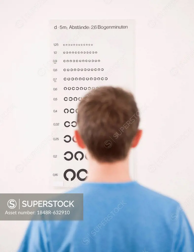 Teenager boy standing in front of an eyesight test