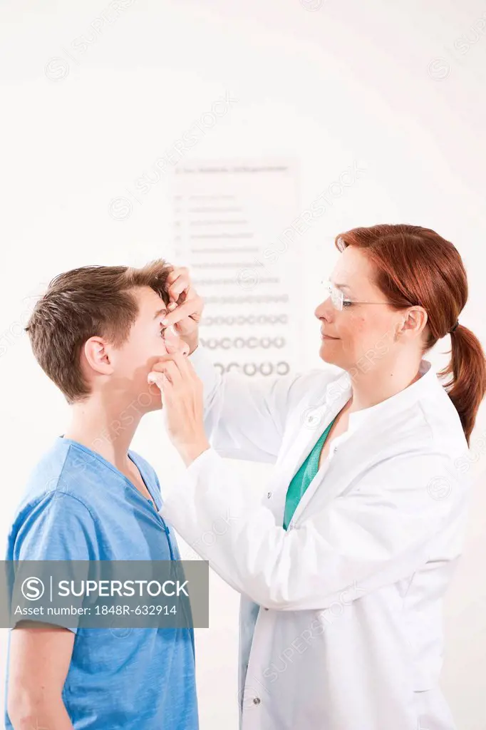 Ophthalmologist examining the eye of a teenage boy