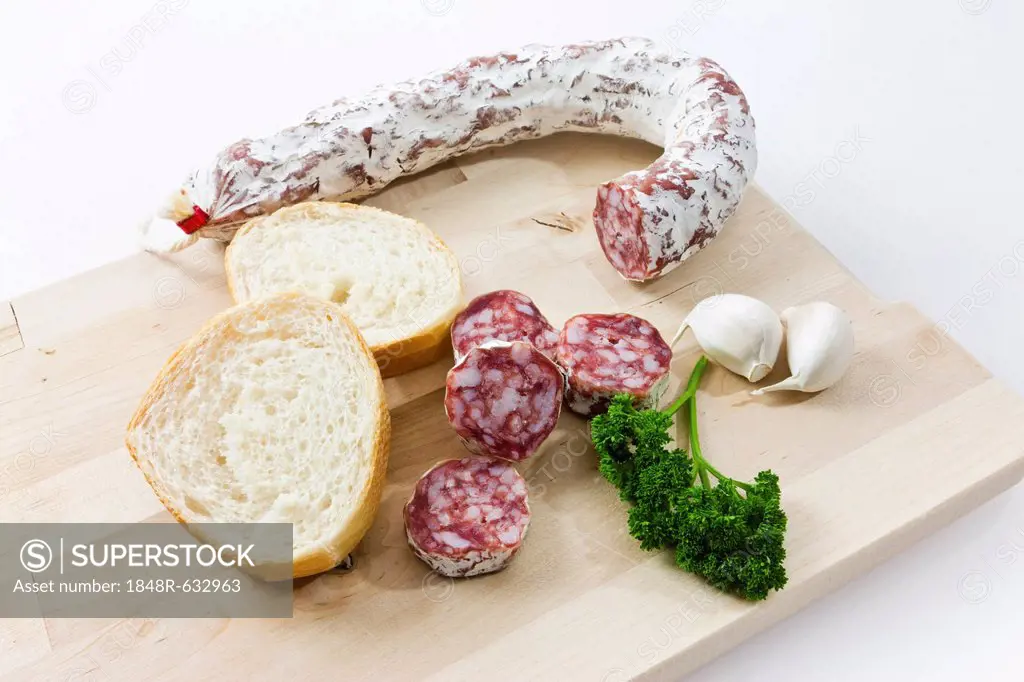 Gourmet salami, premium salami with French bread, garlic and parsley on a wooden board