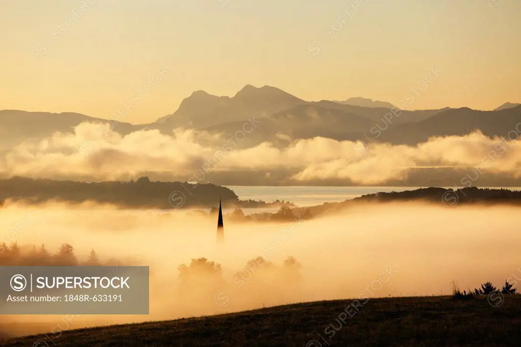Lake Chiemsee and the church steeple of Greimharting as seen from Ratzinger Hoehe in the early morning, Chiemgau, Upper Bavaria, Bavaria, Germany, Eur...