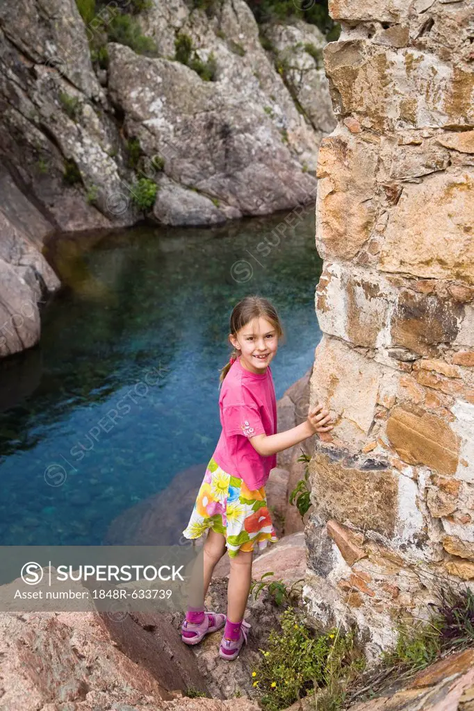7-year-old girl at old Genovese stone bridge over Fango river, Fango Valley, Corsica, France, Europe