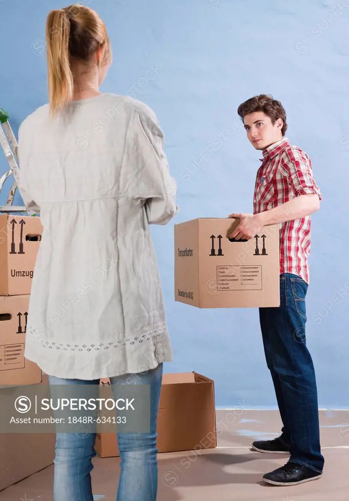 Young couple carrying packing boxes