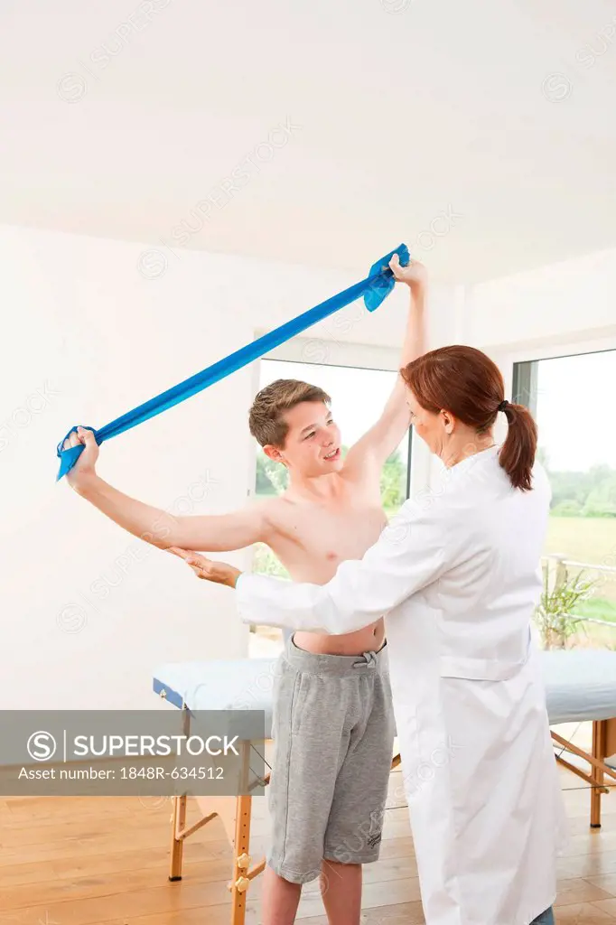 Physiotherapist working with a teenage boy with a Theraband