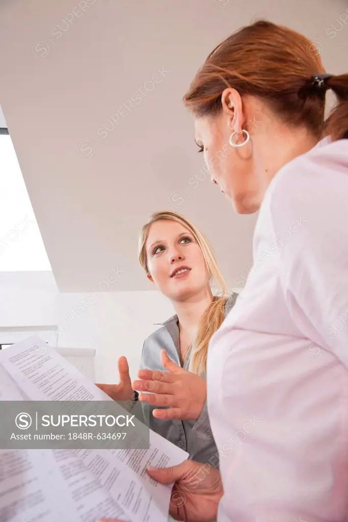 Two women reading a contract together
