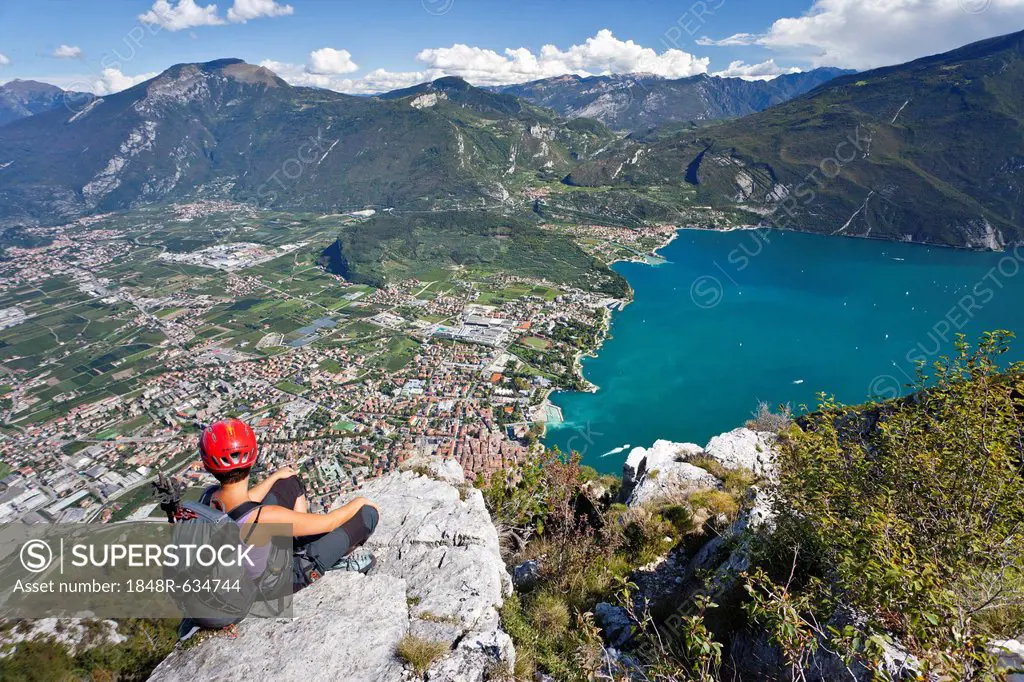 Climber on the Via dell Amicizia climbing route, overlooking Lake Garda and Riva, Trento, Italy, Europe