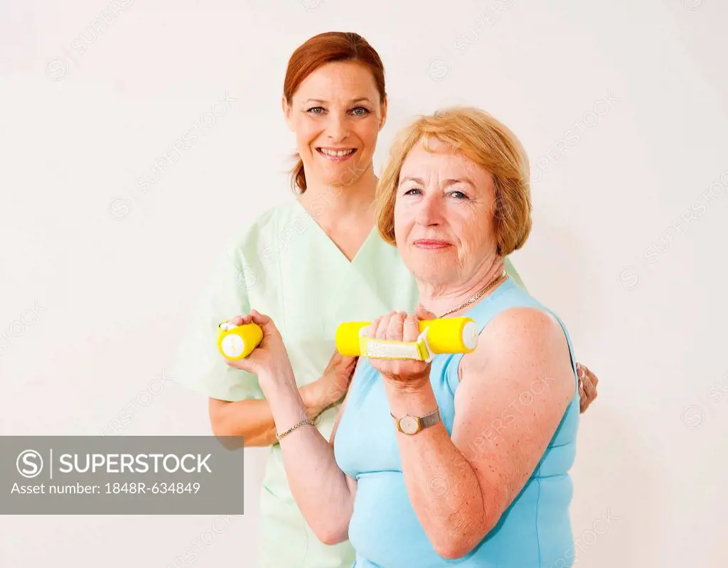 Patient doing physical therapy with dumbbells in a physiotherapist's practice