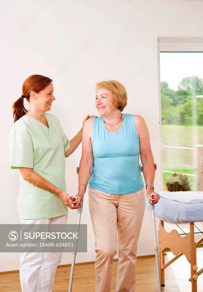 Patient on crutches being supported by her physiotherapist