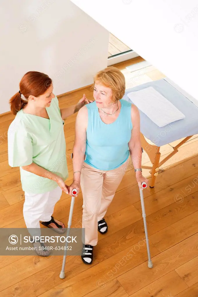 Patient on crutches being supported by her physiotherapist