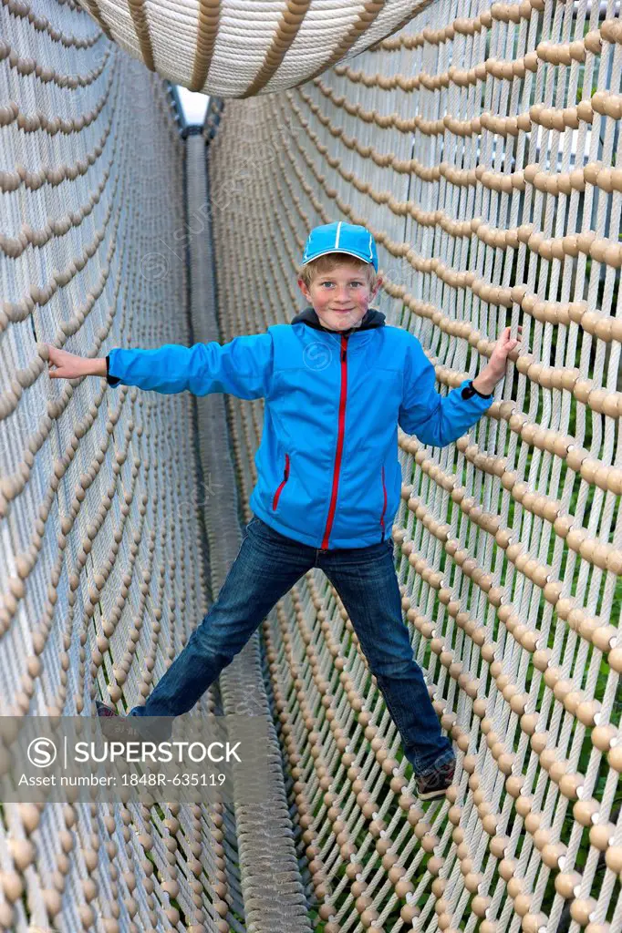Boy, 8, standing in a tunnel made from ropes