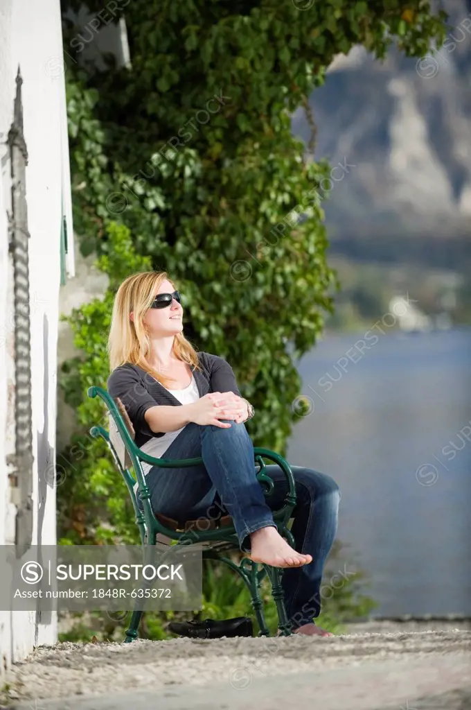 Young woman sitting relaxed in the sunshine, Traunkirchen, Upper Austria, Austria, Europe
