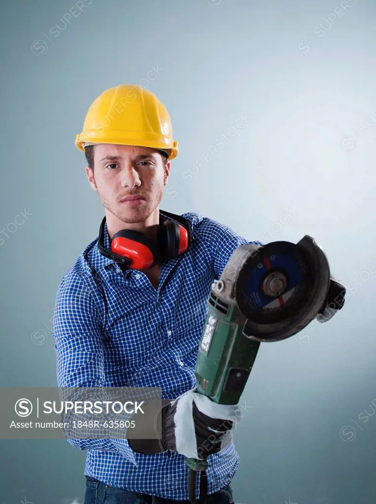 Young tradesman holding an angle grinder