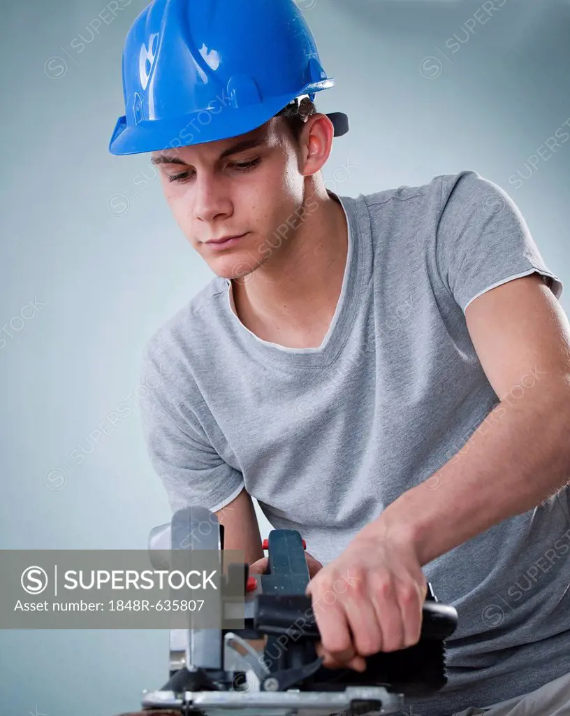 Young tradesman using a jigsaw