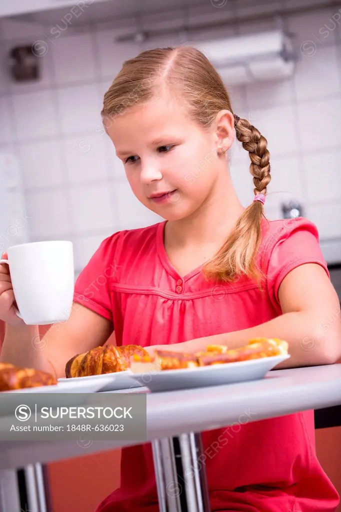 Young girl having breakfast in the kitchen