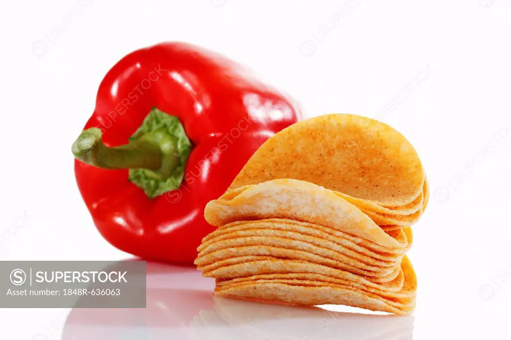 Oval paprika potato chips, stacking chips, stacked beside a capsicum