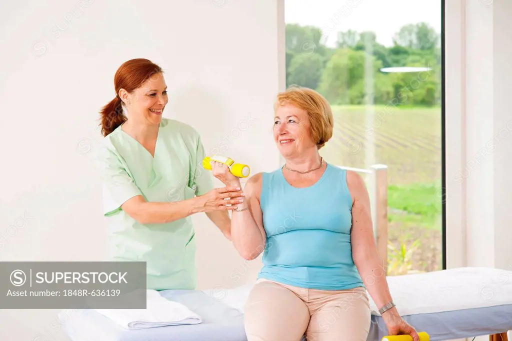 Patient doing physical therapy with dumbbells in a physiotherapist's practice