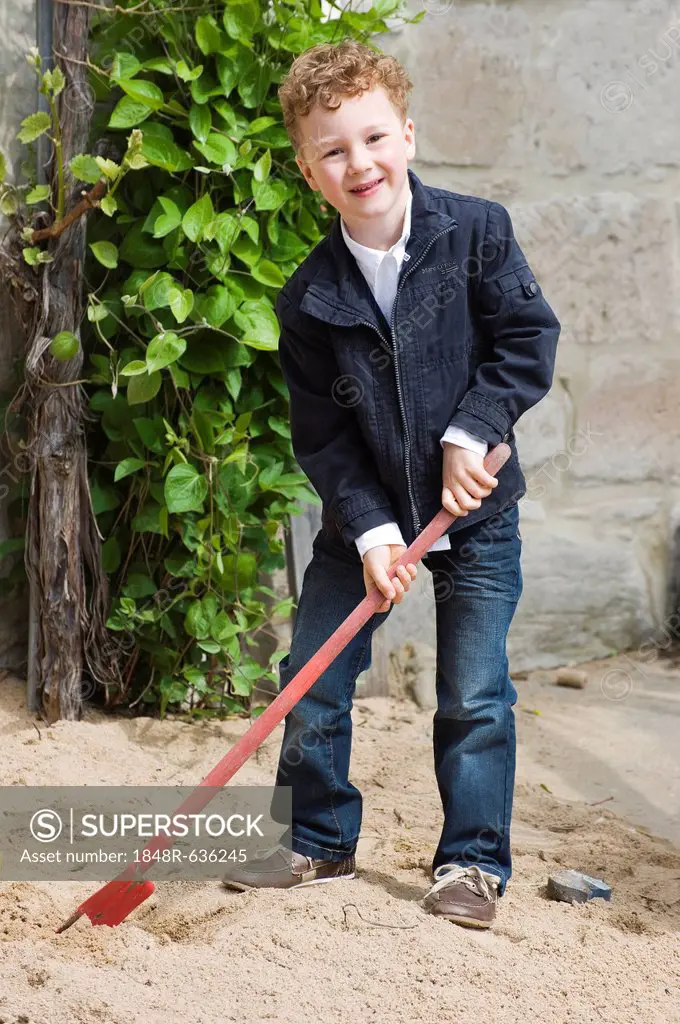 Boy, four years, playing with a shovel