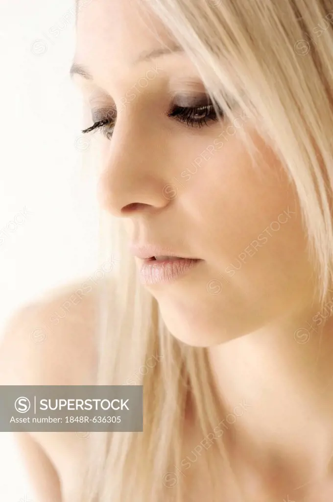 Blonde young woman, looking down, beauty portrait