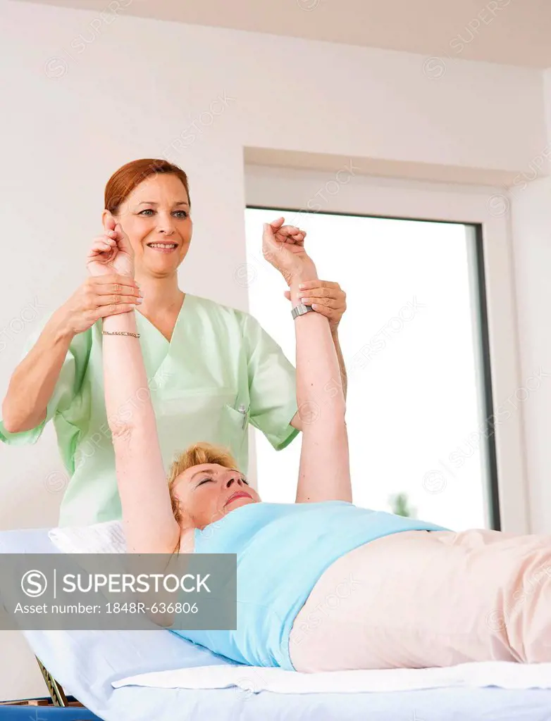 Patient being treated on her shoulders by a physiotherapist