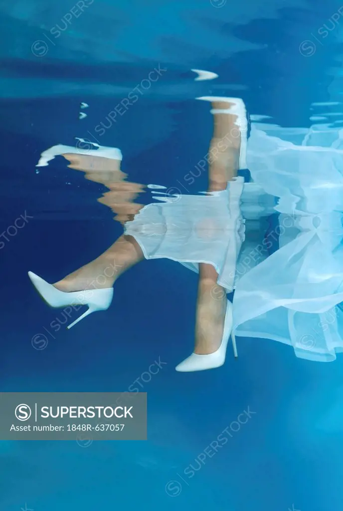 Bride's feet, underwater wedding in pool