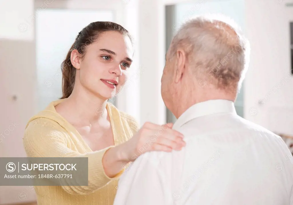 Young woman taking care of an elderly man