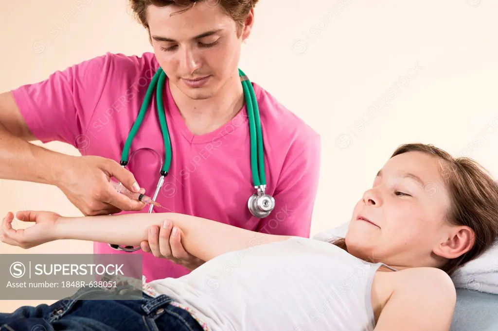 Girl looking afraid while getting a needle from her pediatrician