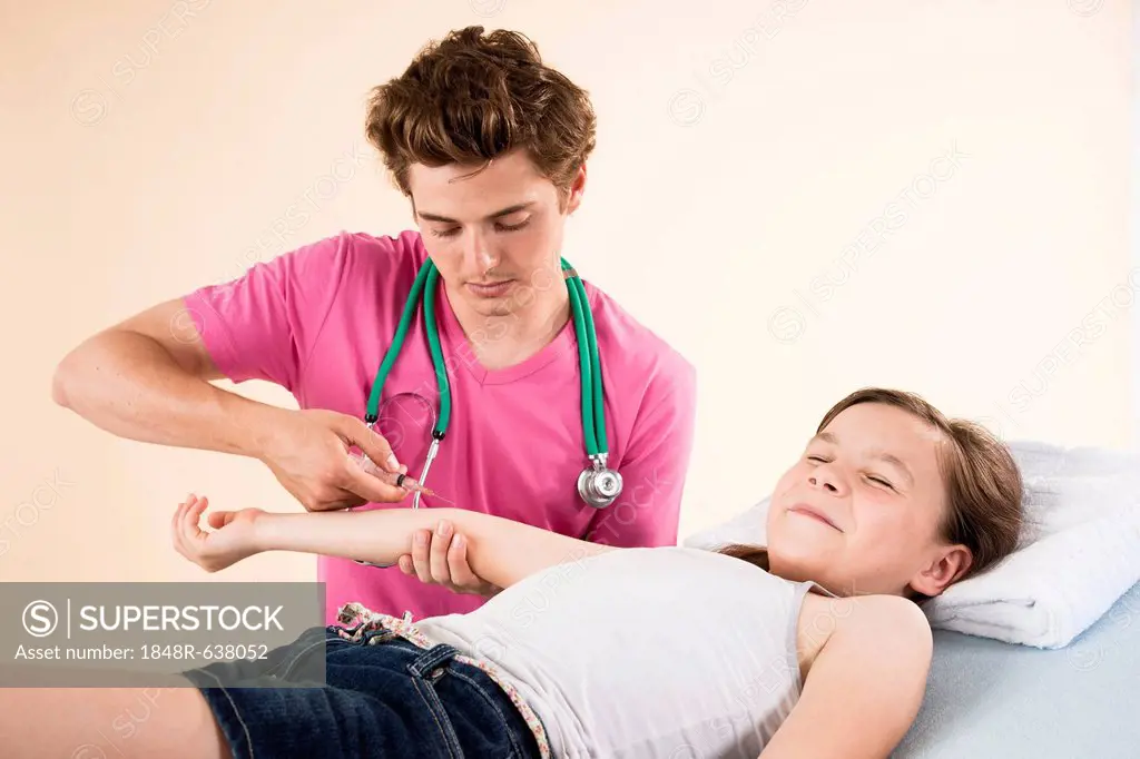 Girl looking afraid while getting a needle from her pediatrician