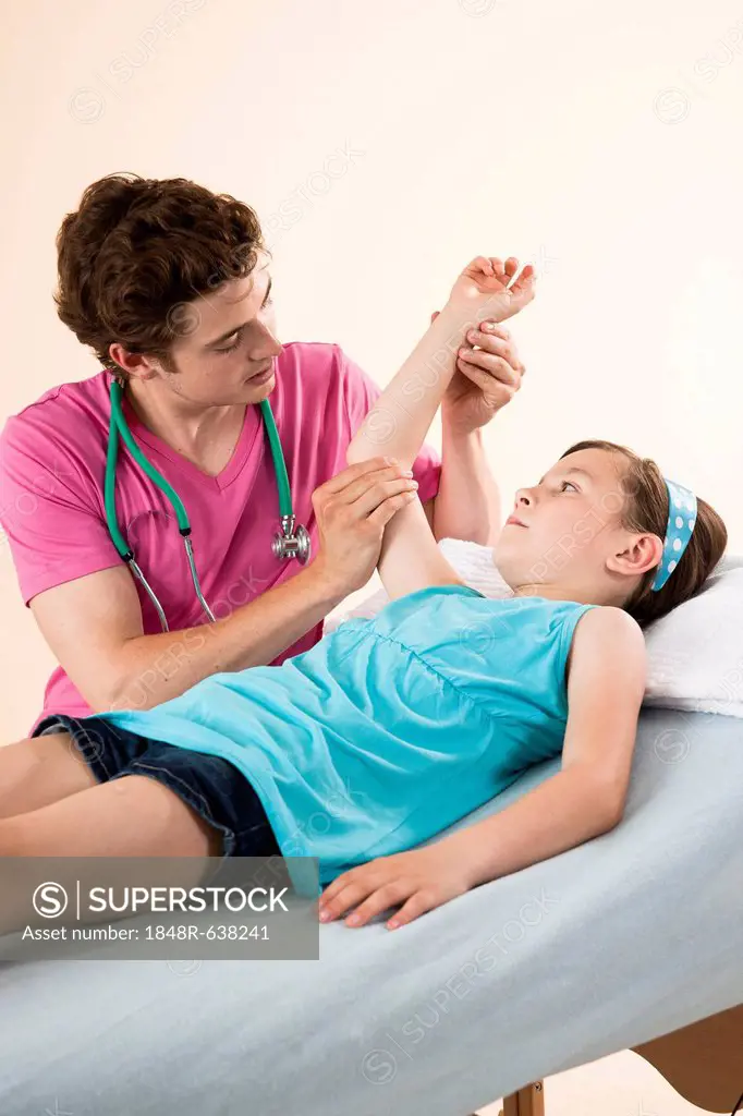 Girl having her arm examined by her pediatrician
