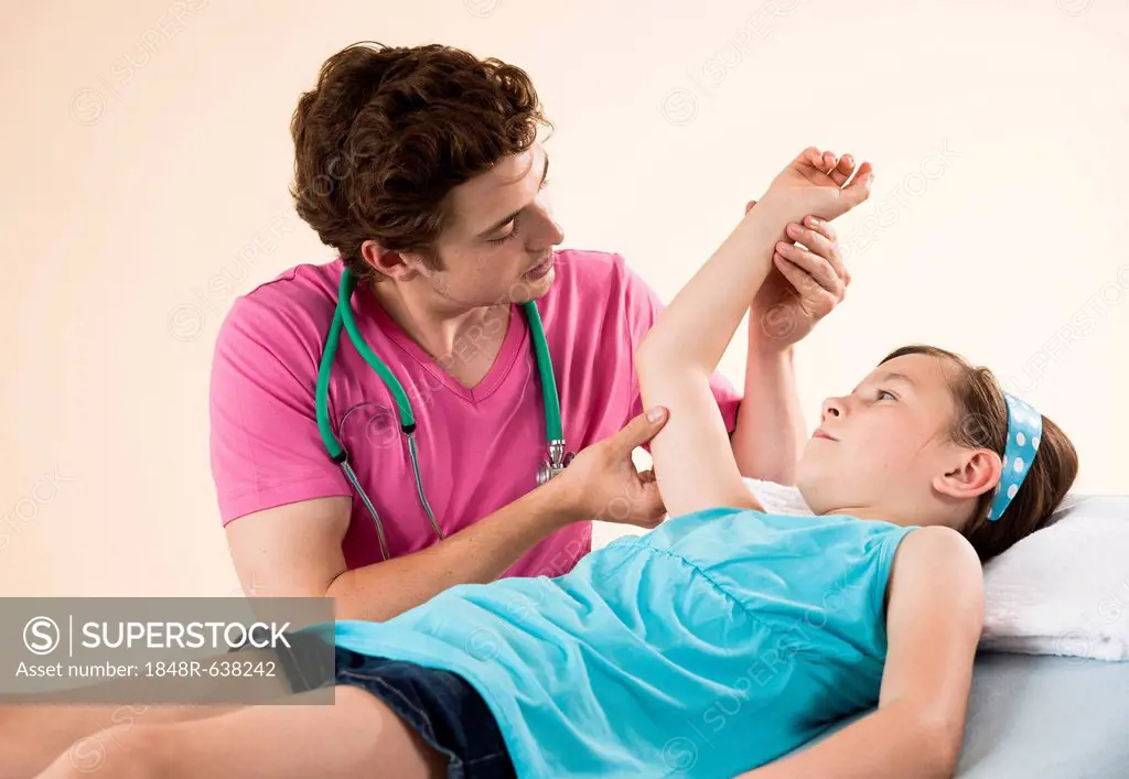 Girl having her arm examined by her pediatrician