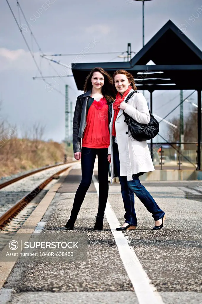Girl and woman on platform of a rail station