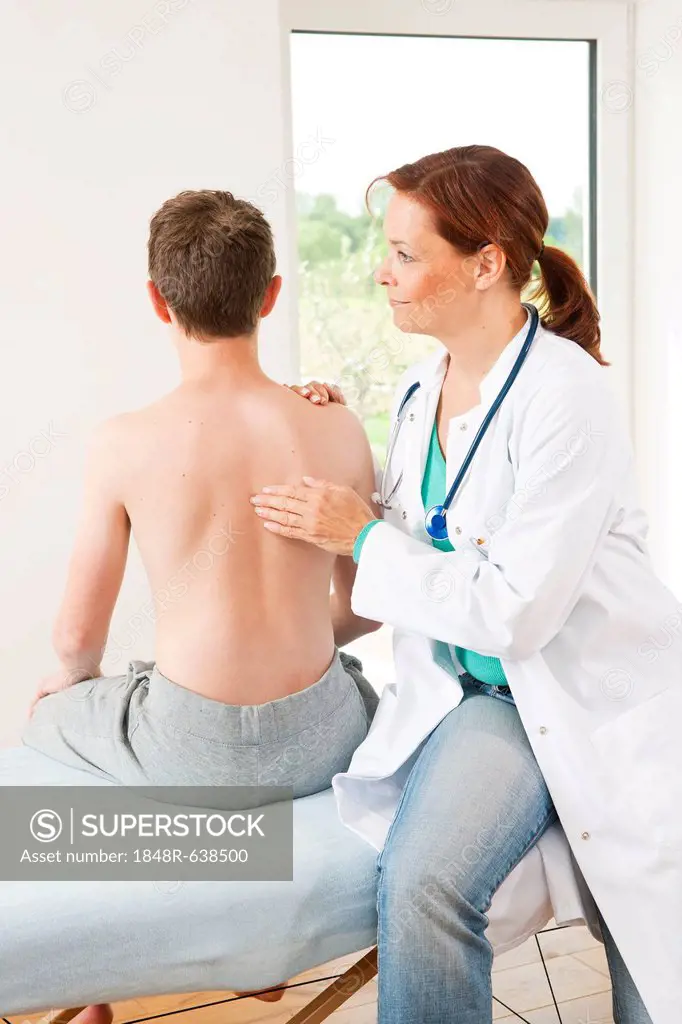 Orthopedic surgeon examining a teenage boy's back