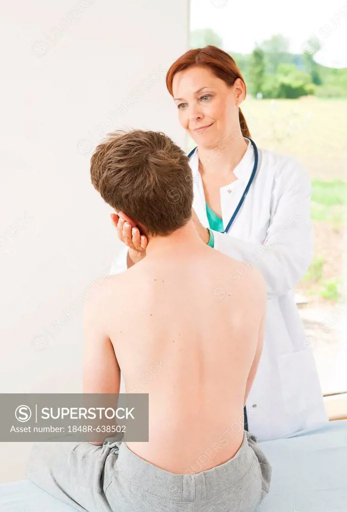 Orthopedic surgeon examining a teenage boy's neck