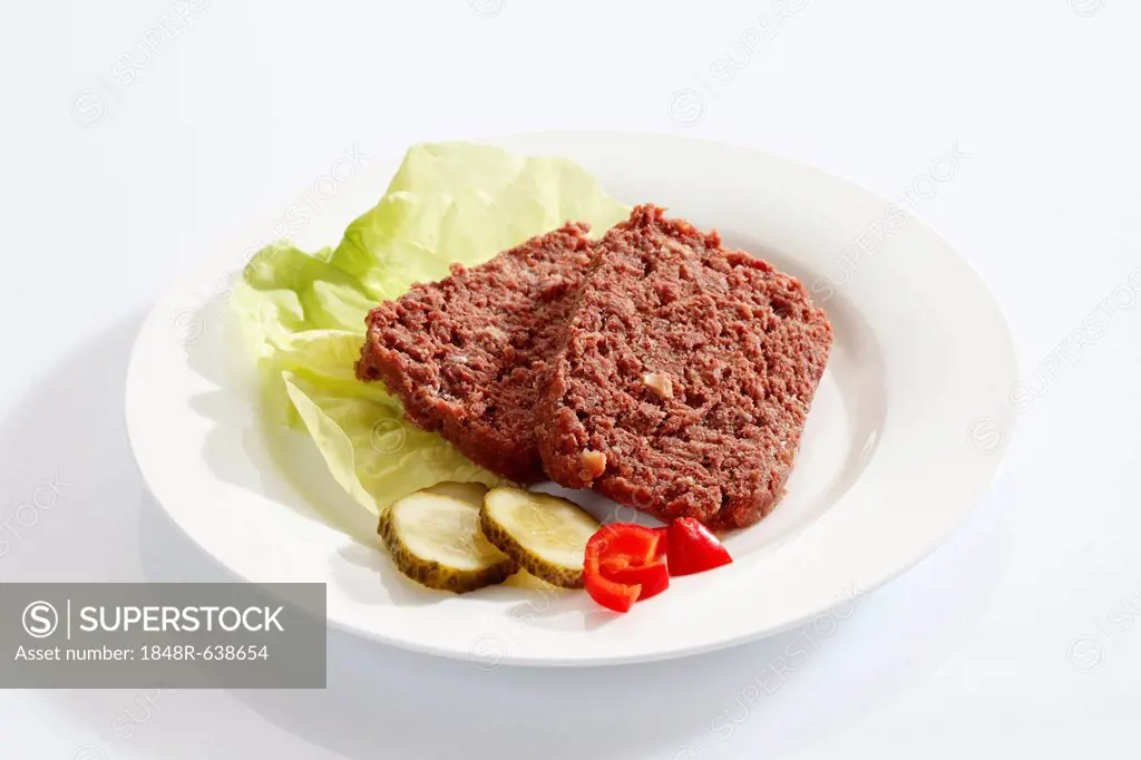 Two slices of corned beef on a white plate