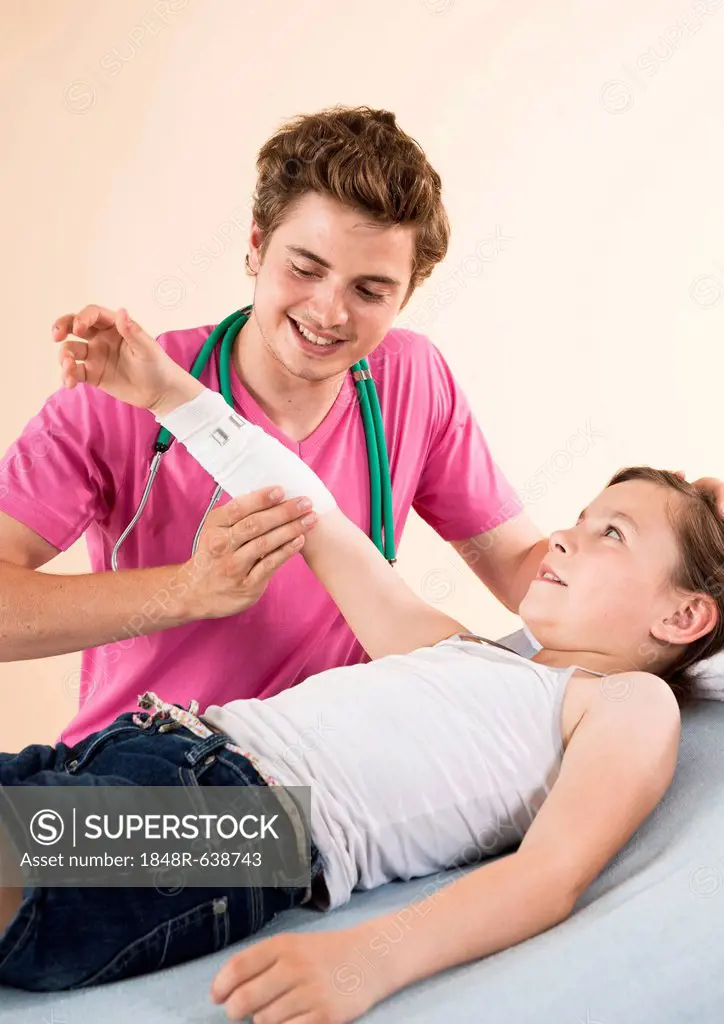 Girl having her arm bandaged by her pediatrician