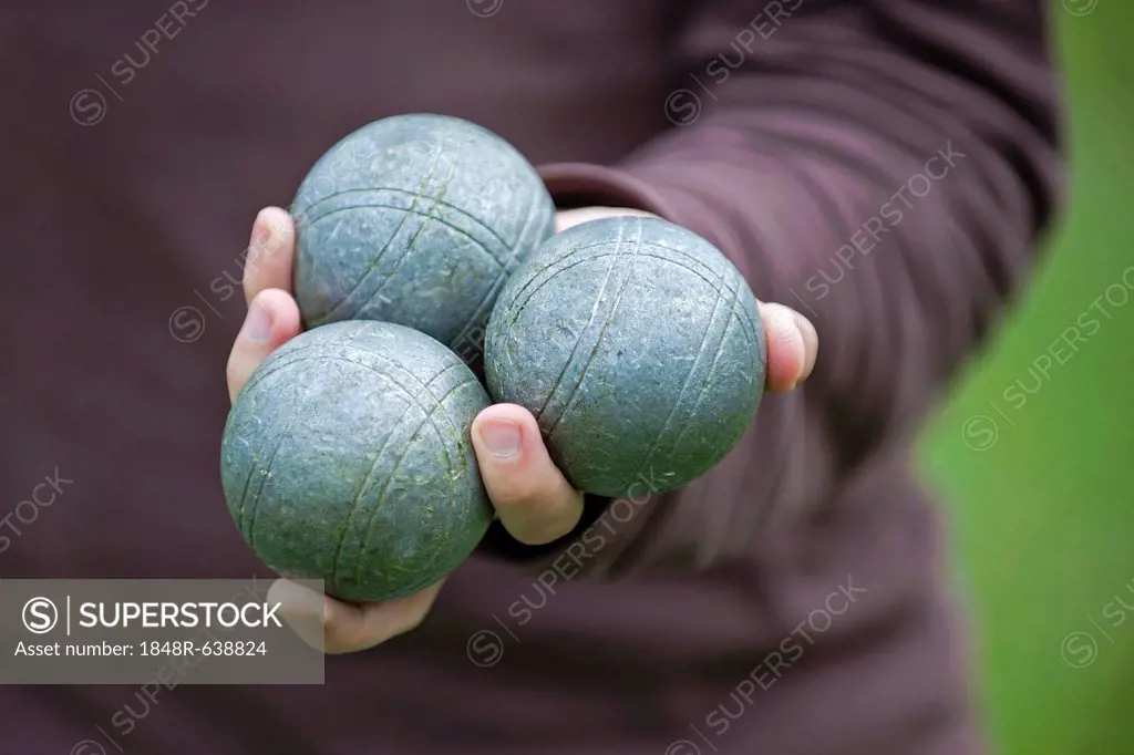Player holding Boules or Pétanque balls in his hand, Colmar, France, Europe