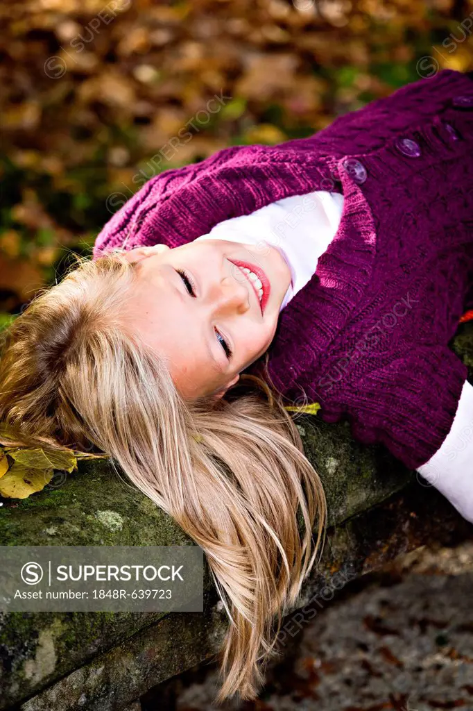 Girl leaning against tree in autumn