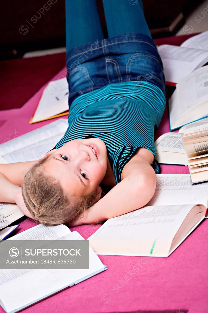 Girl, 8, lying between books