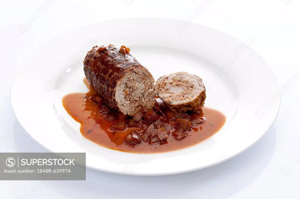Braised pork roulade stuffed with minced meat and onion sauce on a porcelain plate