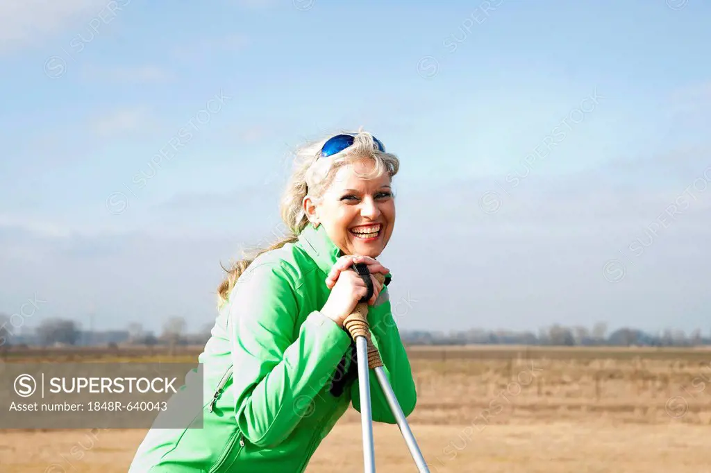 Smiling woman doing Nordic walking