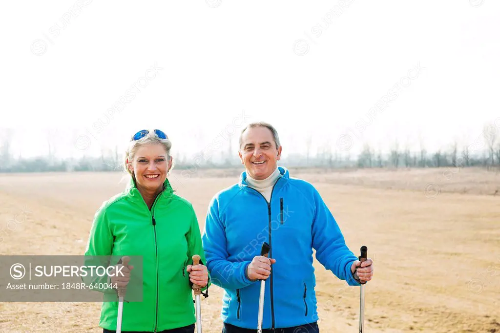 Smiling senior couple doing Nordic walking