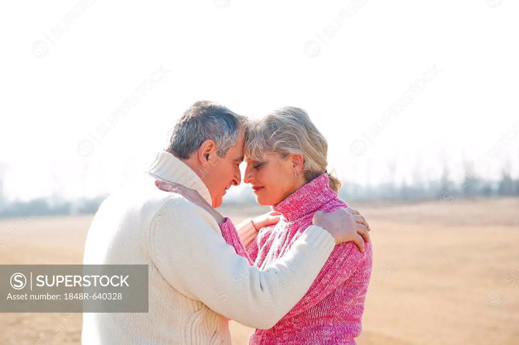 Senior couple hugging with their eyes closed