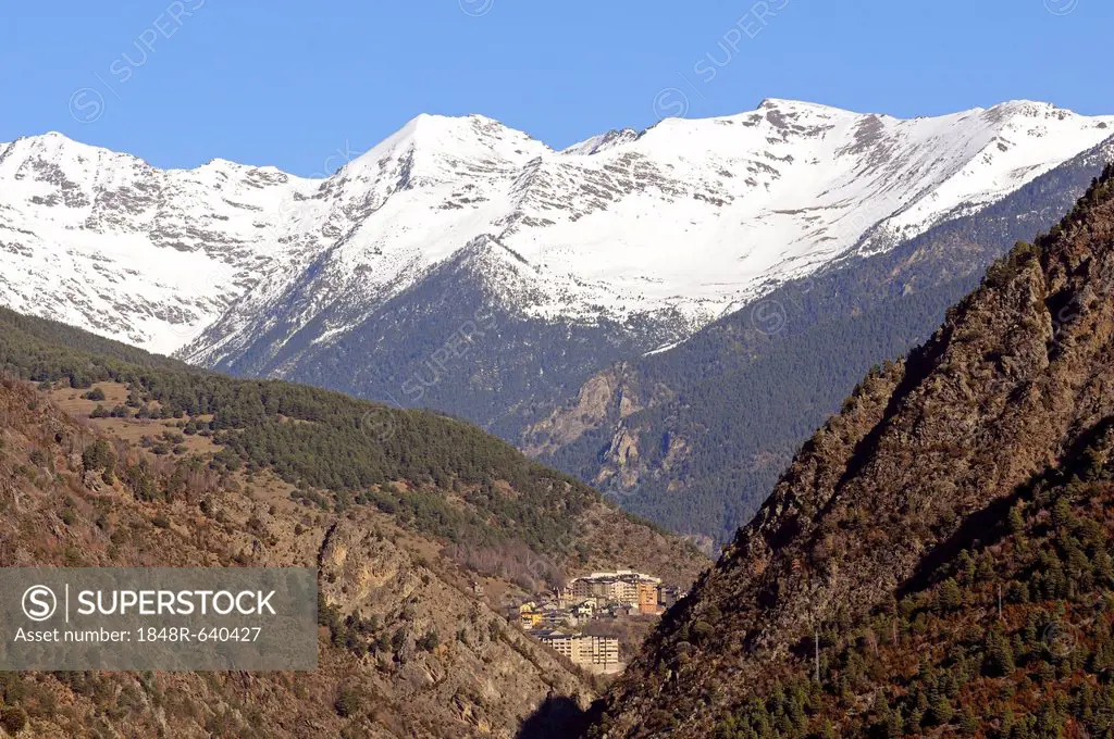 View from La Plana in Andorra La Vella looking north towards the remote mountain village of Sispony in front of the snow-capped peaks of the Pyrenees ...